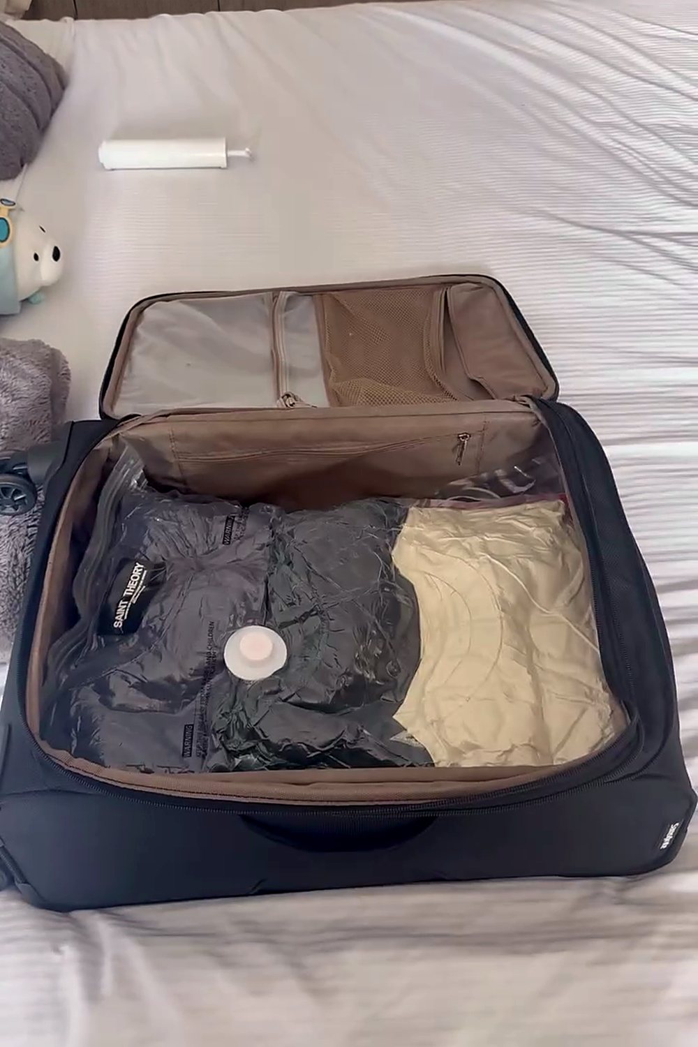 Maleta abierta con la ropa en bolsas al vacío